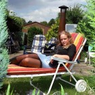 Blondine in Minirock und Nylons liegt im Garten in der Sonne