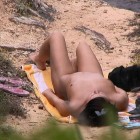 Scharfe Spanner-Fotos einer jungen Frau, die sich beim FKK-Sonnenbad am Strand ganz alleine und unbeobachtet glaubt.