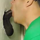 Junger Kerl bläst am Glory Hole einen schwarzen Schwanz und leckt ihm die Eier, bis er alles in den Mund gespritzt bekommt.